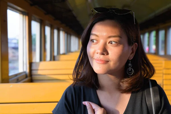 Tvář ženy mladé krásné asijské turistické myšlení uvnitř vlaku — Stock fotografie