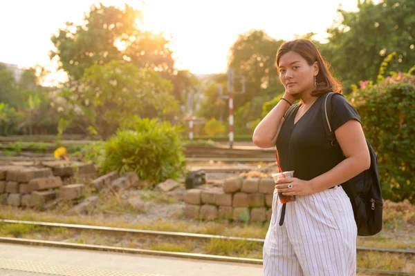 Mladá Asiatka turistické žena batohem drží sody na nádraží — Stock fotografie
