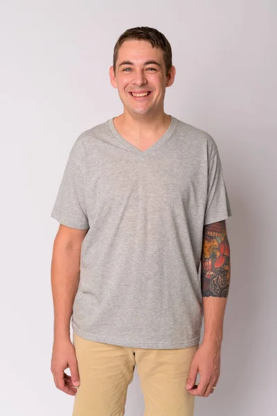 Портрет счастливого красивого мужчины с татуировками на руках, улыбающегося — стоковое фото