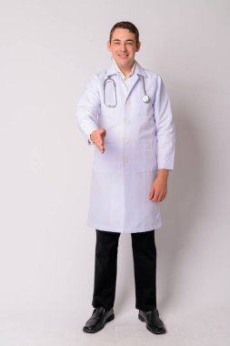 Tüm vücut çekim el sıkışma vererek mutlu yakışıklı adam doktor