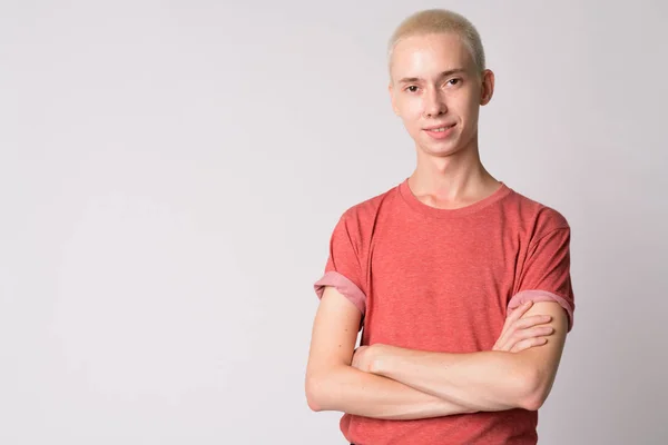 Portret van jonge gelukkig androgyne man die lacht met gekruiste armen — Stockfoto