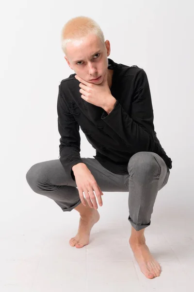 Volledige lichaam schot van ernstige androgyne jongeman crouching — Stockfoto