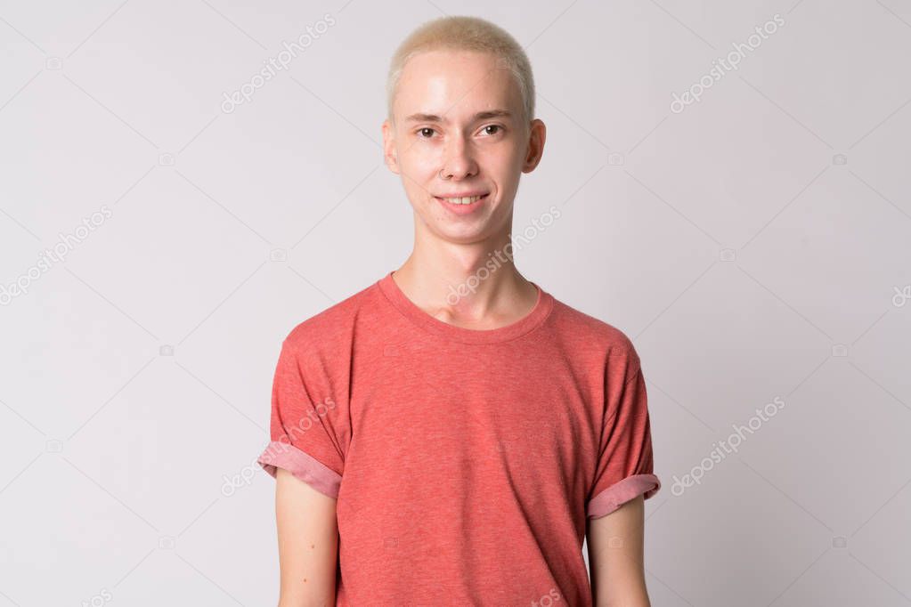 Face of happy young handsome androgynous man smiling