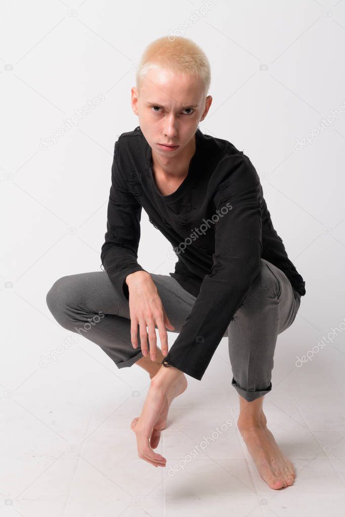 Full body shot of young handsome androgynous man crouching