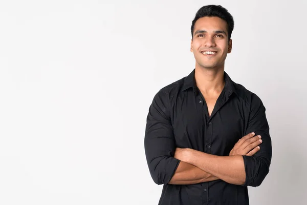 Portrait of young happy Indian businessman thinking with arms crossed — Stock Photo, Image