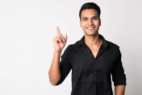 Portrait of young happy Indian businessman pointing up — Stock Photo, Image