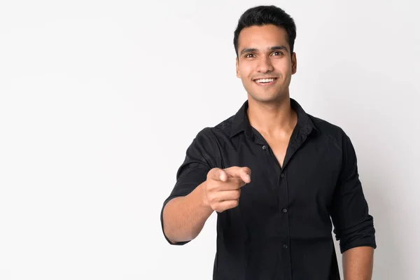 Portrait of young happy Indian businessman pointing at camera — Stock Photo, Image