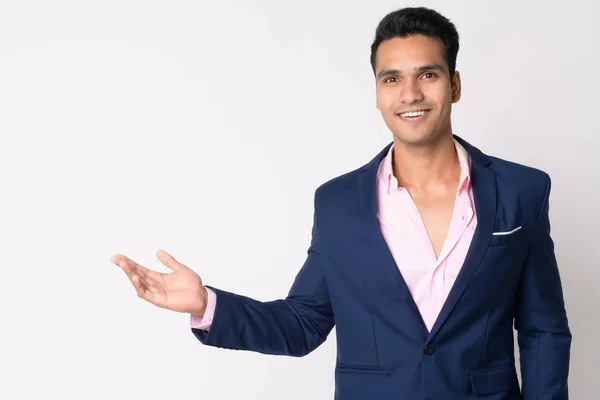 Retrato de un joven empresario indio feliz en traje mostrando algo — Foto de Stock