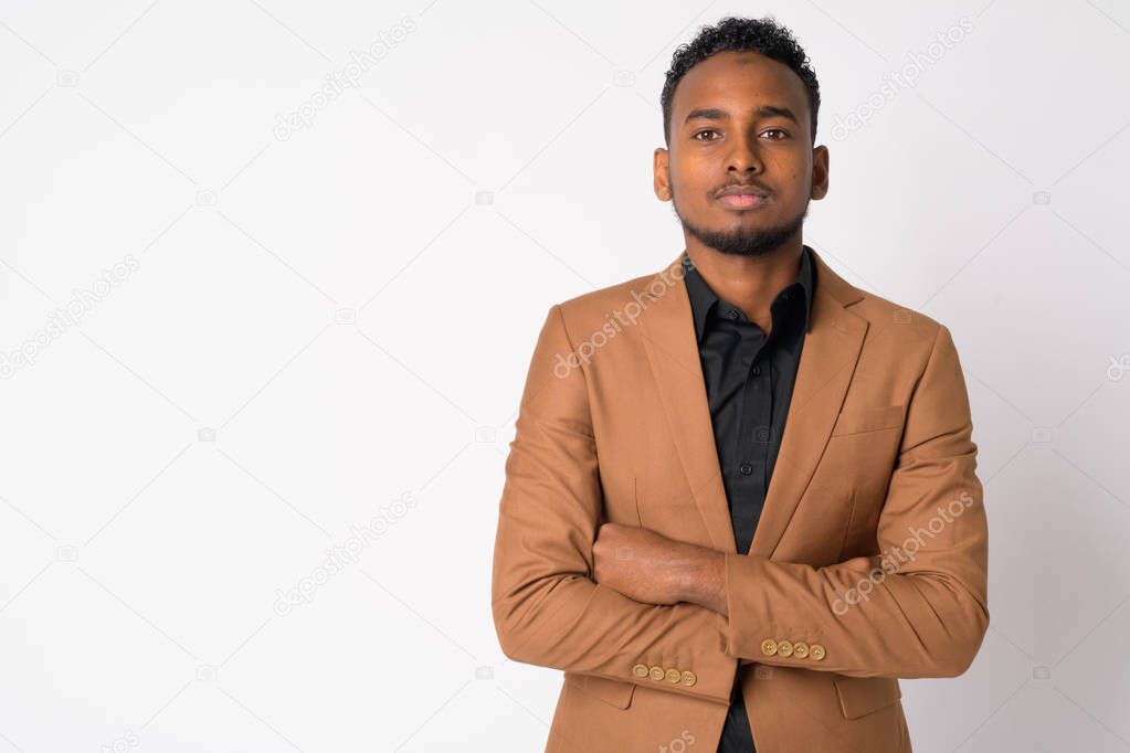 Portrait of young handsome African businessman with arms crossed