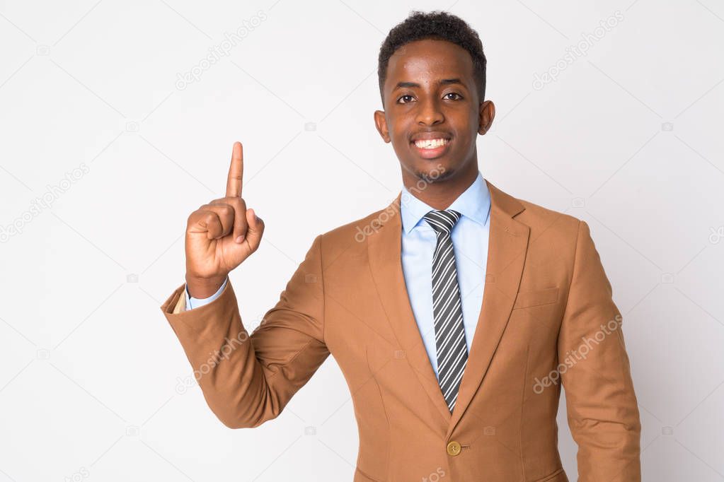 Portrait of young happy African businessman pointing up