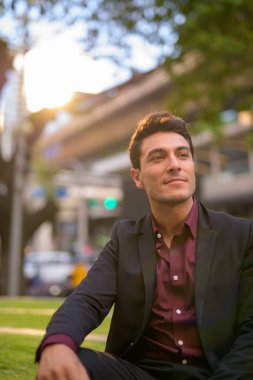 Düşünme ve doğayla şehirde oturan yakışıklı İspanyol işadamı