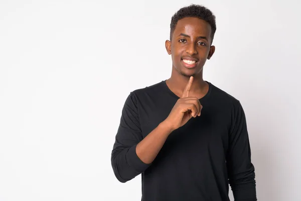 Porträt eines glücklichen jungen Afrikaners mit dem Finger auf den Lippen — Stockfoto