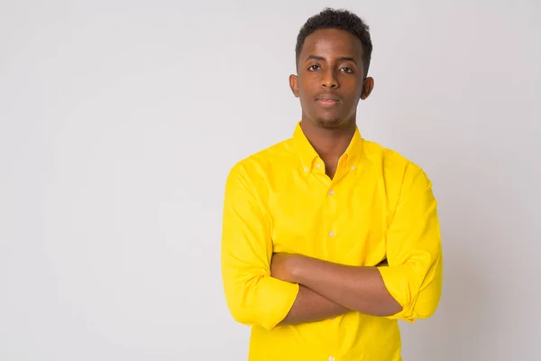 Joven empresario africano con camisa amarilla cruzando brazos — Foto de Stock