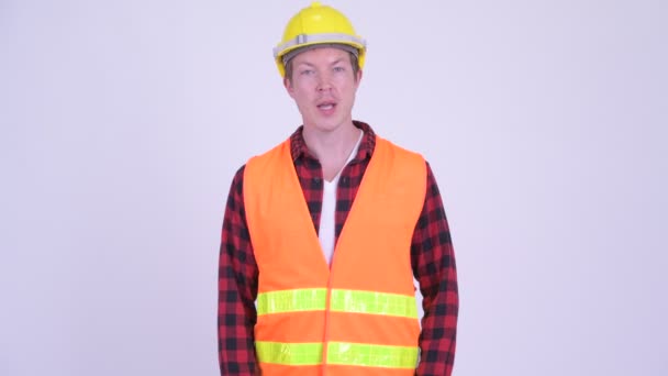 Gelukkig jongeman bouwvakker iets uit te leggen — Stockvideo
