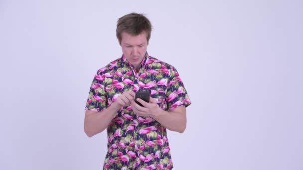 Happy young fat tourist man with big belly using phone and getting good news — Stock Video