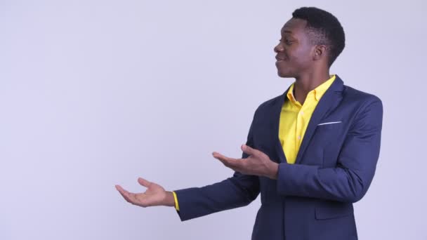 Junger glücklicher afrikanischer Geschäftsmann zeigt etwas — Stockvideo