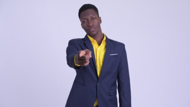 Junger glücklicher afrikanischer Geschäftsmann im Anzug zeigt in die Kamera — Stockvideo