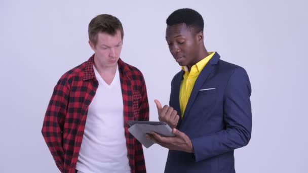 Multi-ethnic young businessmen talking and using digital tablet together — Stock Video