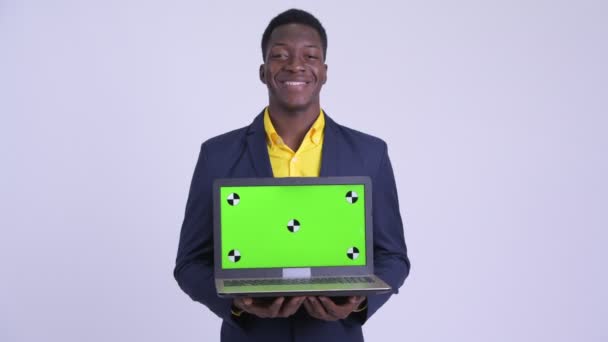 Giovane felice uomo d'affari africano spiegando mentre mostra laptop — Video Stock
