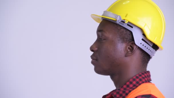 Closeup profile view of happy young African man construction worker thinking — Stock Video