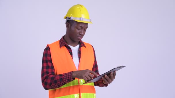 Junger gestresster afrikanischer Bauarbeiter hält Klemmbrett und drückt Daumen nach unten — Stockvideo