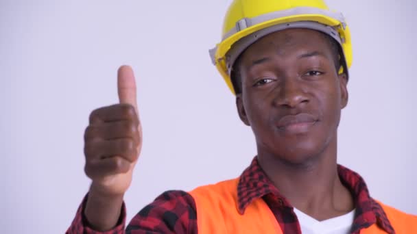 Gesicht eines jungen glücklichen afrikanischen Mannes Bauarbeiter gibt Daumen hoch — Stockvideo