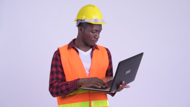 Młody szczęśliwy African mężczyzna budowlanych robotnik za pomocą laptopa — Wideo stockowe