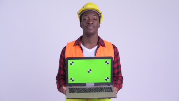 Jeune homme africain heureux travailleur de la construction montrant ordinateur portable — Video