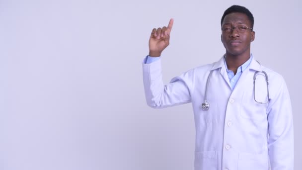 Young happy African man doctor thinking and pointing up — Stock Video
