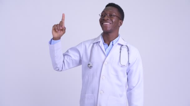 Joven hombre africano feliz médico señalando hacia arriba — Vídeo de stock