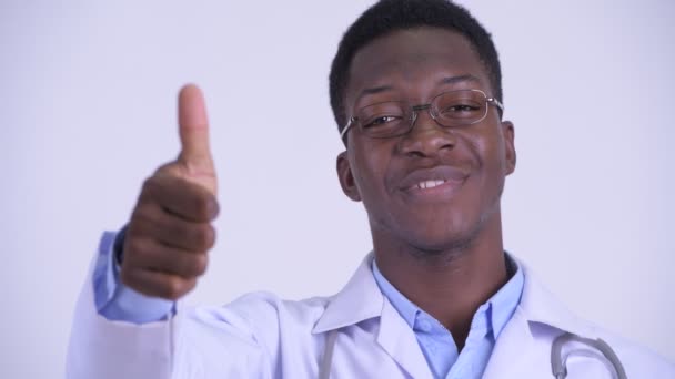 Лицо молодого счастливого африканского мужчины-врача, показывающего большие пальцы — стоковое видео