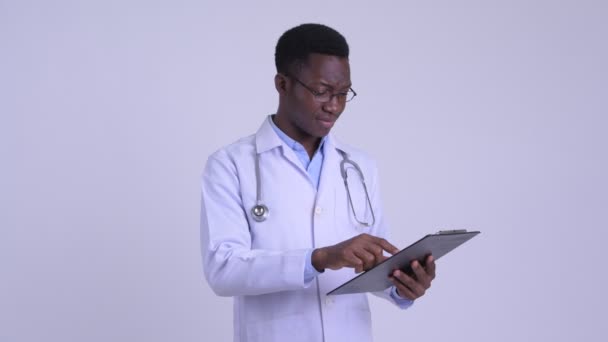 Young stressed African man doctor reading on clipboard and giving thumbs down — Stock Video