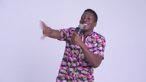 Молодой счастливый африканский турист поет с микрофоном — стоковое видео