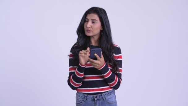 Glad ung vacker Persiska kvinna tänkande medan du använder telefonen — Stockvideo