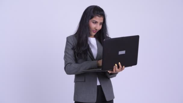 Giovane felice donna d'affari persiana pensando durante l'utilizzo del computer portatile — Video Stock