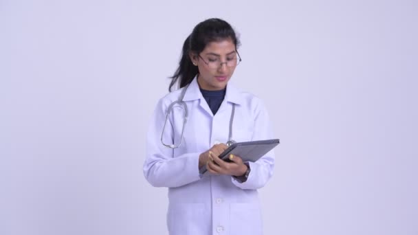 Giovane felice medico donna persiana pensando durante l'utilizzo di tablet digitale — Video Stock