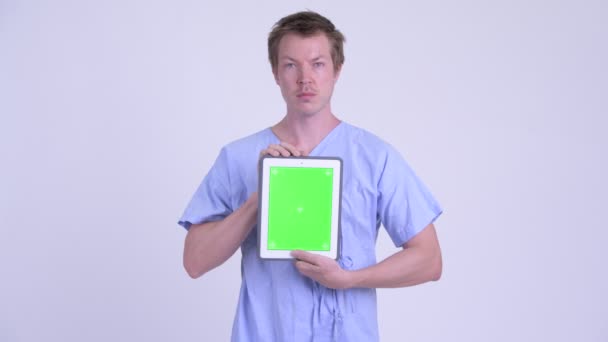 Portrait of young man patient showing digital tablet — Stock Video