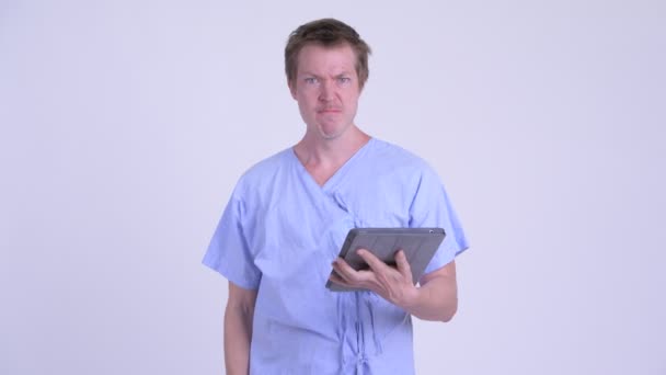 Gek jonge man patiënt met behulp van digitale tablet en het krijgen van slecht nieuws — Stockvideo