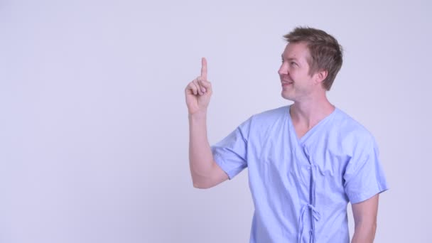 Gelukkige jonge man patiënt denken en omhoog te wijzen — Stockvideo