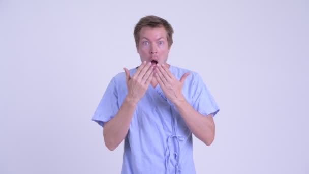 Ung man patienten som täcker munnen och ser chockad — Stockvideo