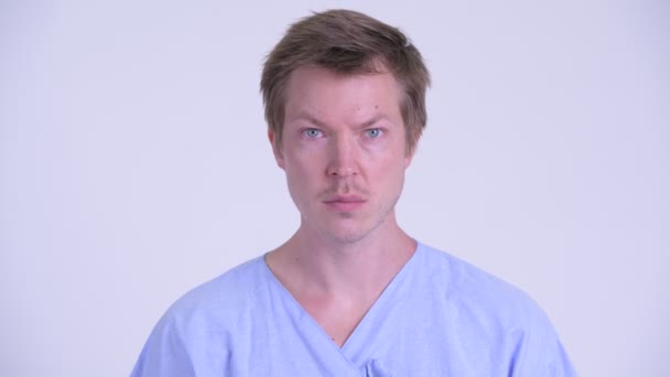 Face of young man patient covering mouth and looking shocked — Stock Video