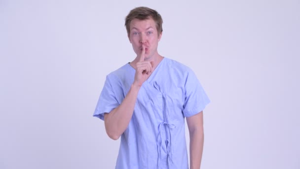 Portret pacjenta roześmiany szczęśliwy młody człowiek, z palcem na ustach — Wideo stockowe