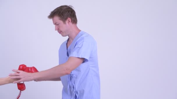 Hasta üzerinde eski telefon ve kızmaya genç adam — Stok video