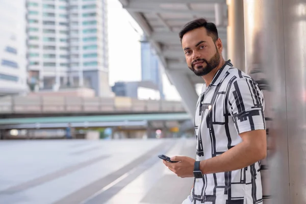 Joven barbudo hombre indio usando el teléfono al aire libre — Foto de Stock