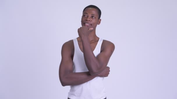 Junger glücklicher afrikanischer Mann denkt und blickt auf — Stockvideo
