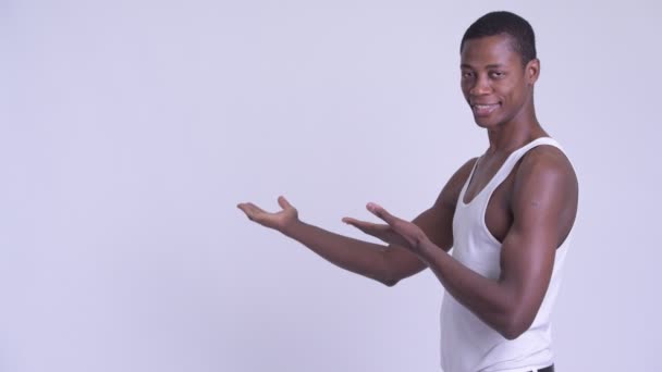 Jovem homem africano feliz mostrando algo nas costas — Vídeo de Stock