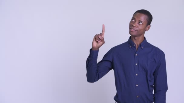 Jonge gelukkige Afrikaanse zakenman denken en omhoog te wijzen — Stockvideo
