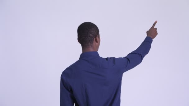 Rear view of young African businessman directing and pointing finger — Stock Video