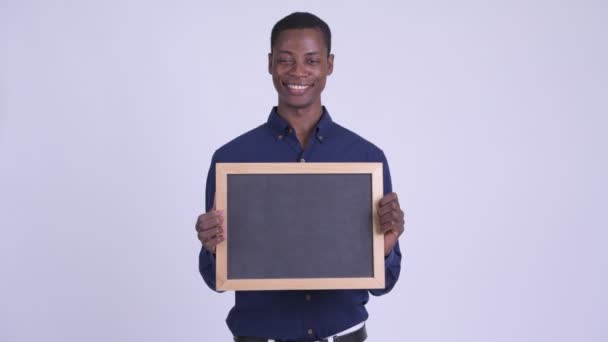 Jonge gelukkig Afrikaanse zakenman holding blackboard — Stockvideo
