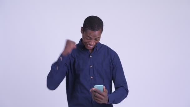 Junger glücklicher afrikanischer Geschäftsmann telefoniert und bekommt gute Nachrichten — Stockvideo